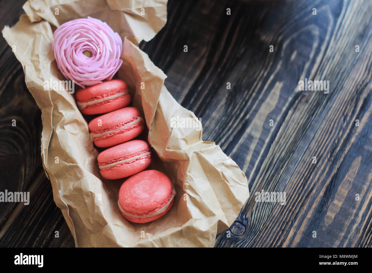 Amaretti colorati e fiori sul tavolo Foto Stock