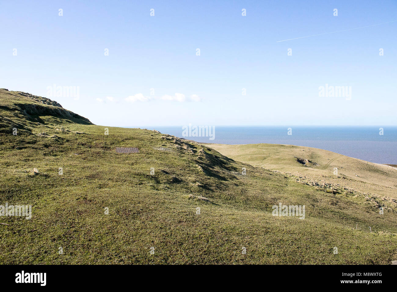 Vista del paesaggio di montagne e il mare con la fattoria eolica presso il Great Orme mountain a Llandudno, Galles Foto Stock