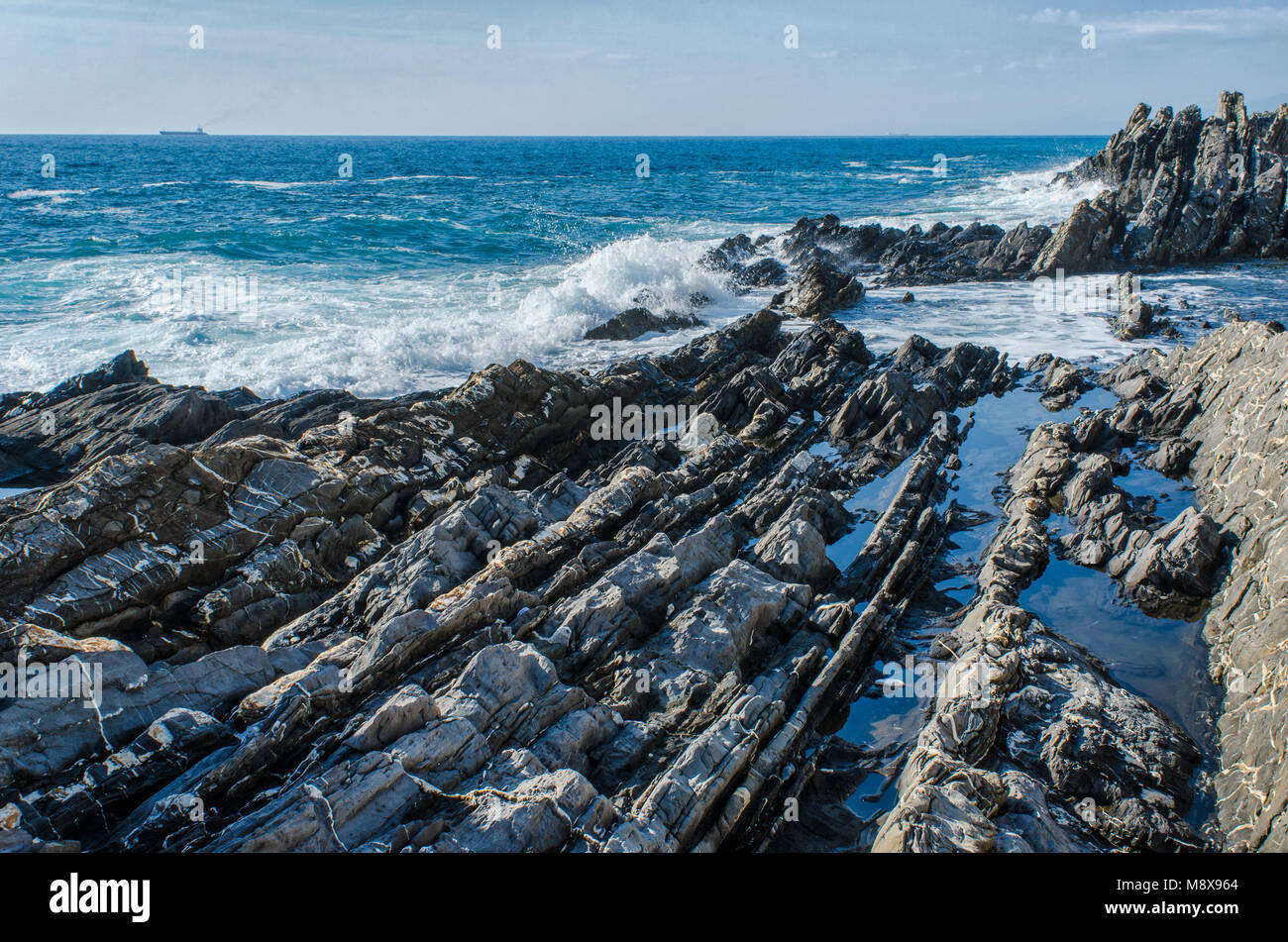 Sharp e ruvide rocce di roccia che emergono dalle acque del mare Mediterraneo sulla Costa di Genova Nervi in Italia Foto Stock