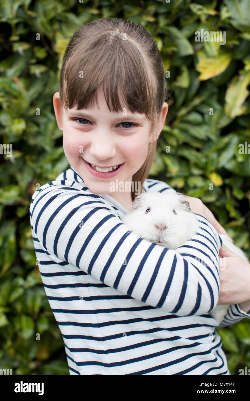 Ritratto di ragazza in giardino alla ricerca dopo il Pet cavia Foto Stock