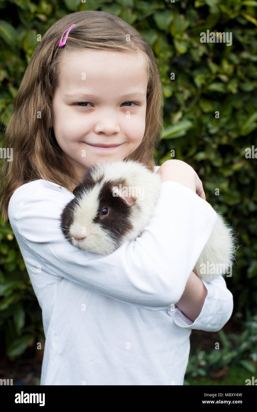 Ritratto di ragazza in giardino alla ricerca dopo il Pet cavia Foto Stock