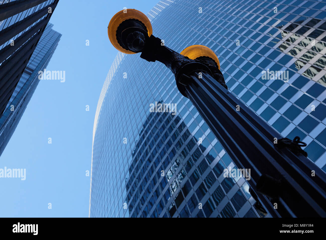 Guardando il lampione con cielo blu e Palazzo di Vetro riflessioni in background. Foto Stock