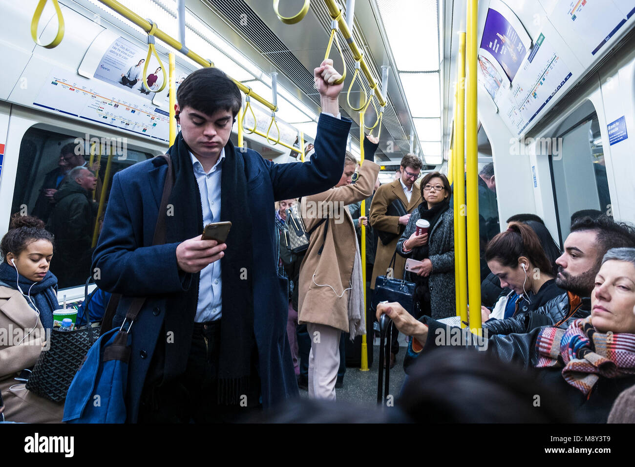 Pendolari che viaggiano per lavorare su una Londra metropolitana treno. Foto Stock