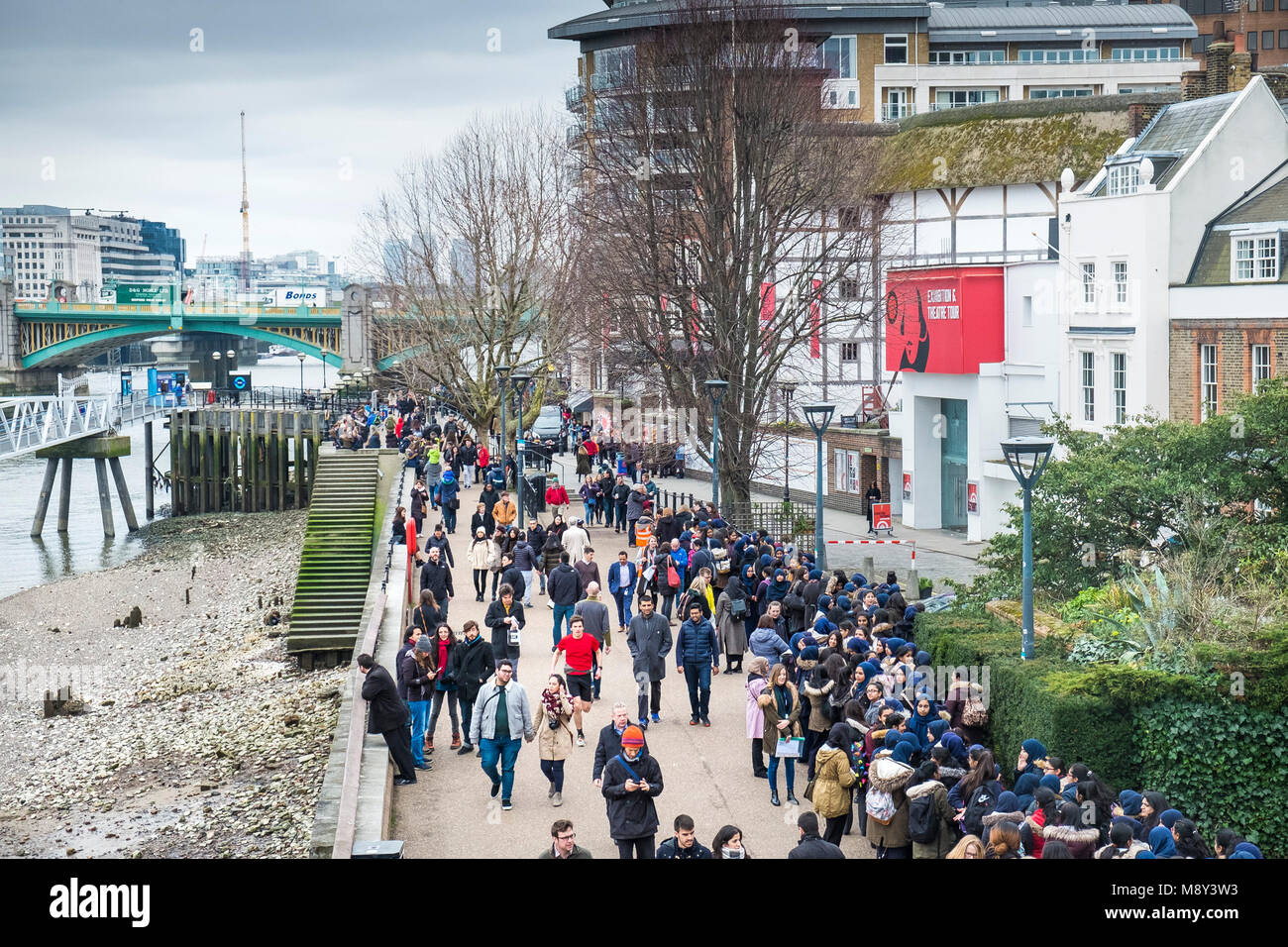 La gente camminare in piedi e in attesa fuori il Globe Theatre sulla South Bank di Londra. Foto Stock