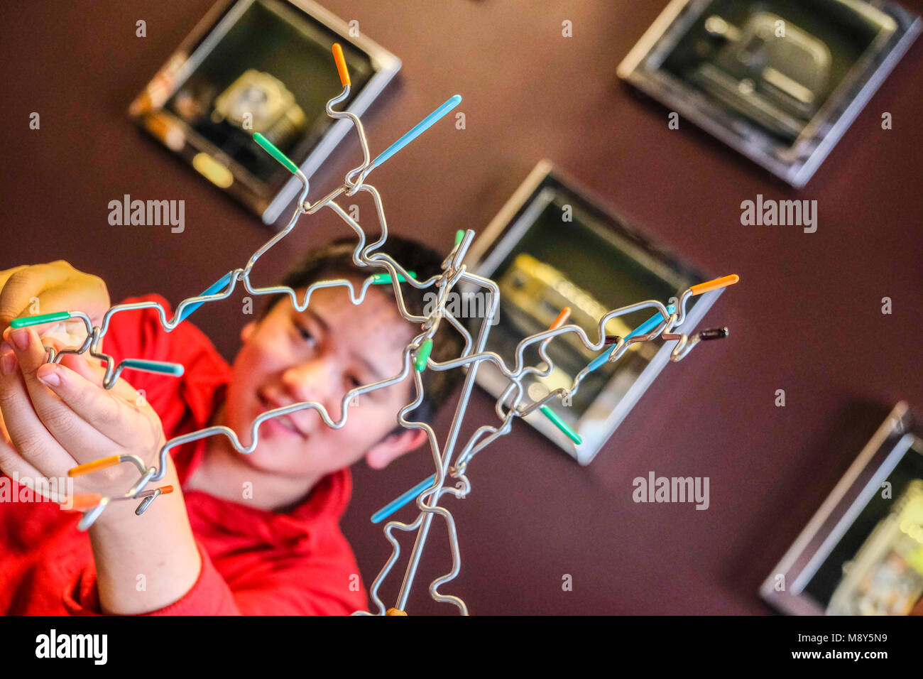 Un bambino gioca il bilanciamento magnetico si inceppa in una sala gioco Foto Stock