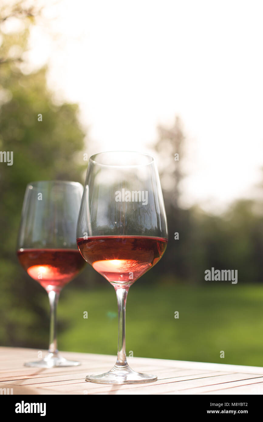 Due bicchieri di vino rosato su un tavolo per esterno Foto Stock