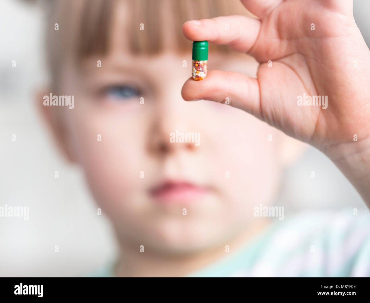 Giovane ragazza mostra il suo masticabile vitamina c tablet Foto Stock