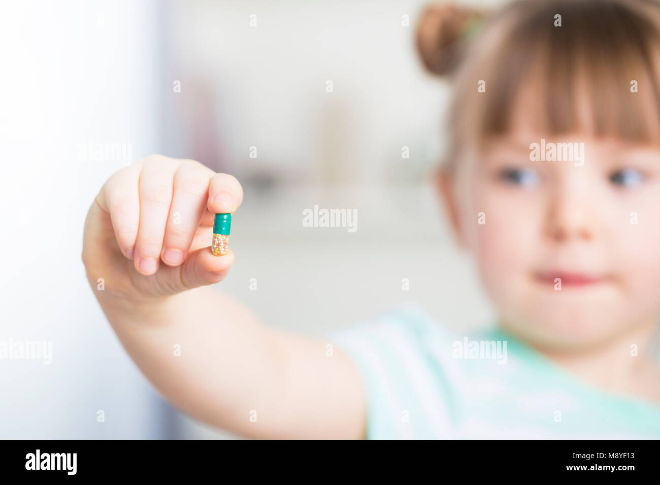 Giovane ragazza mostra il suo masticabile vitamina c tablet Foto Stock