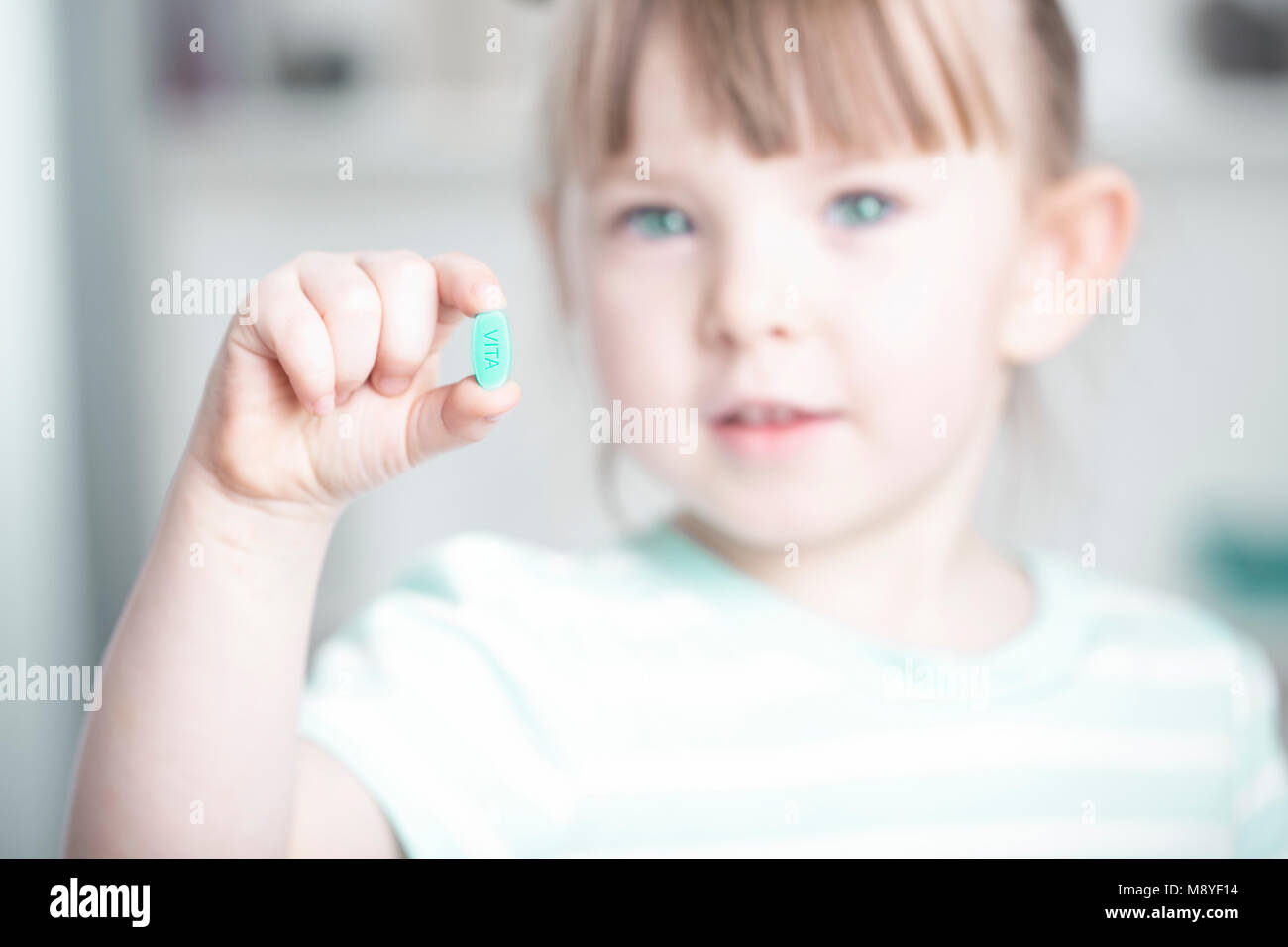 Giovane ragazza mostra il suo masticabile vitamina c tablet Foto Stock