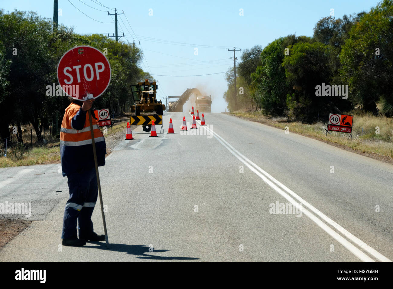 Operaio stradale il traffico di controllo con un segnale di stop, Australia occidentale Foto Stock