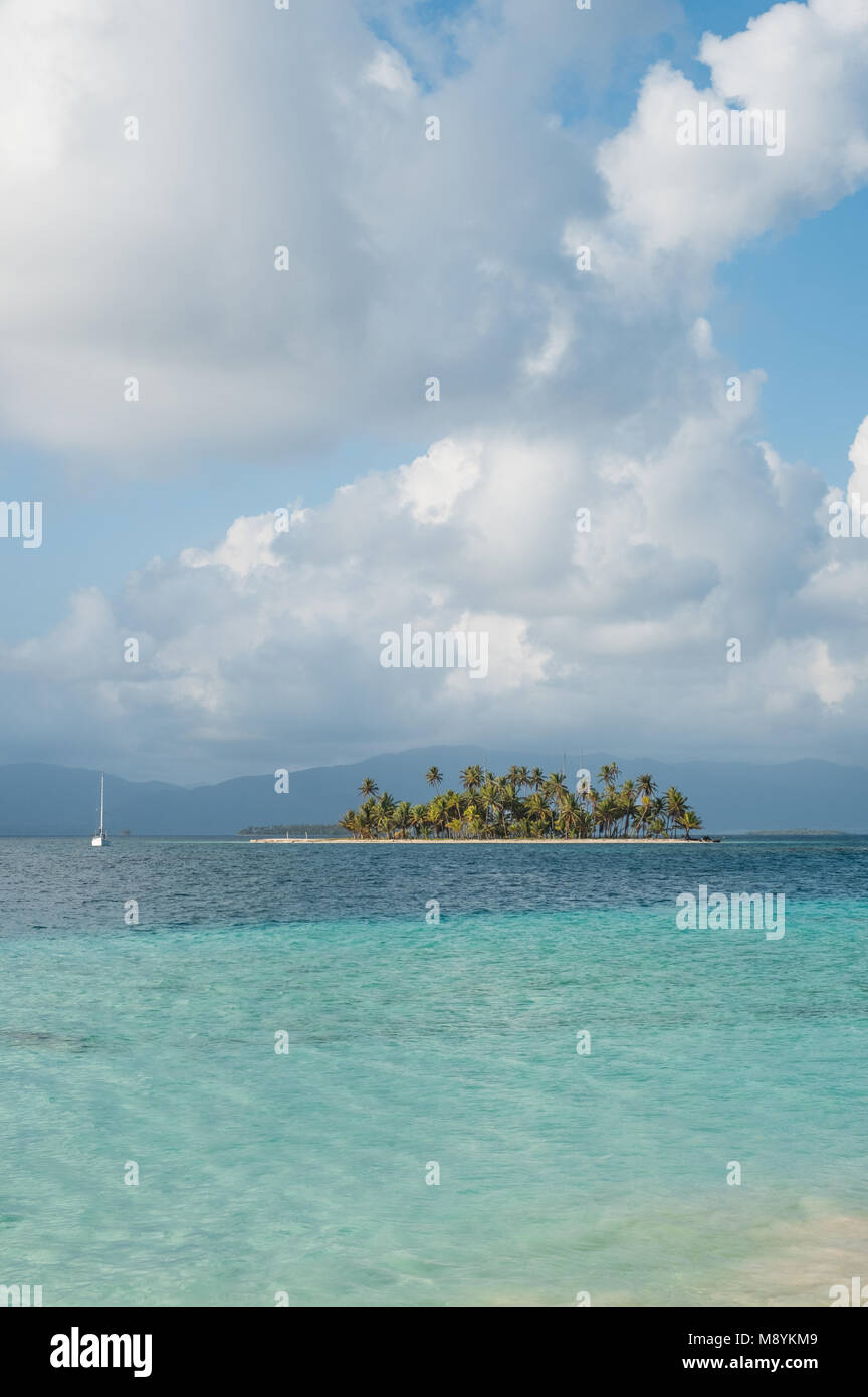 Piccola isola e barca a vela nel Mar dei Caraibi - isole San Blas - spiaggia perfetta, palme e acqua chiara - Guna Yala, Panama Foto Stock