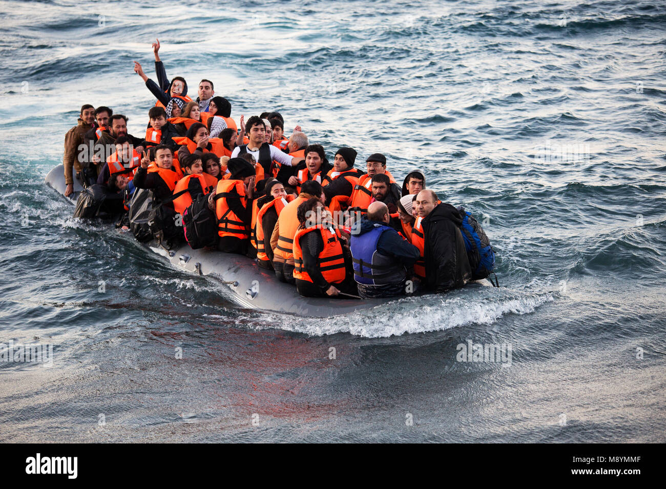 Richiedenti asilo celebrando dopo la traversata del mare Egeo dalla Turchia nel brutto tempo. Nel 2015 più di un milione di immigrati arrivati in Europa dal mare. Gli immigrati sono principalmente di rifugiati che fuggono dalla guerra in Siria. Foto Stock