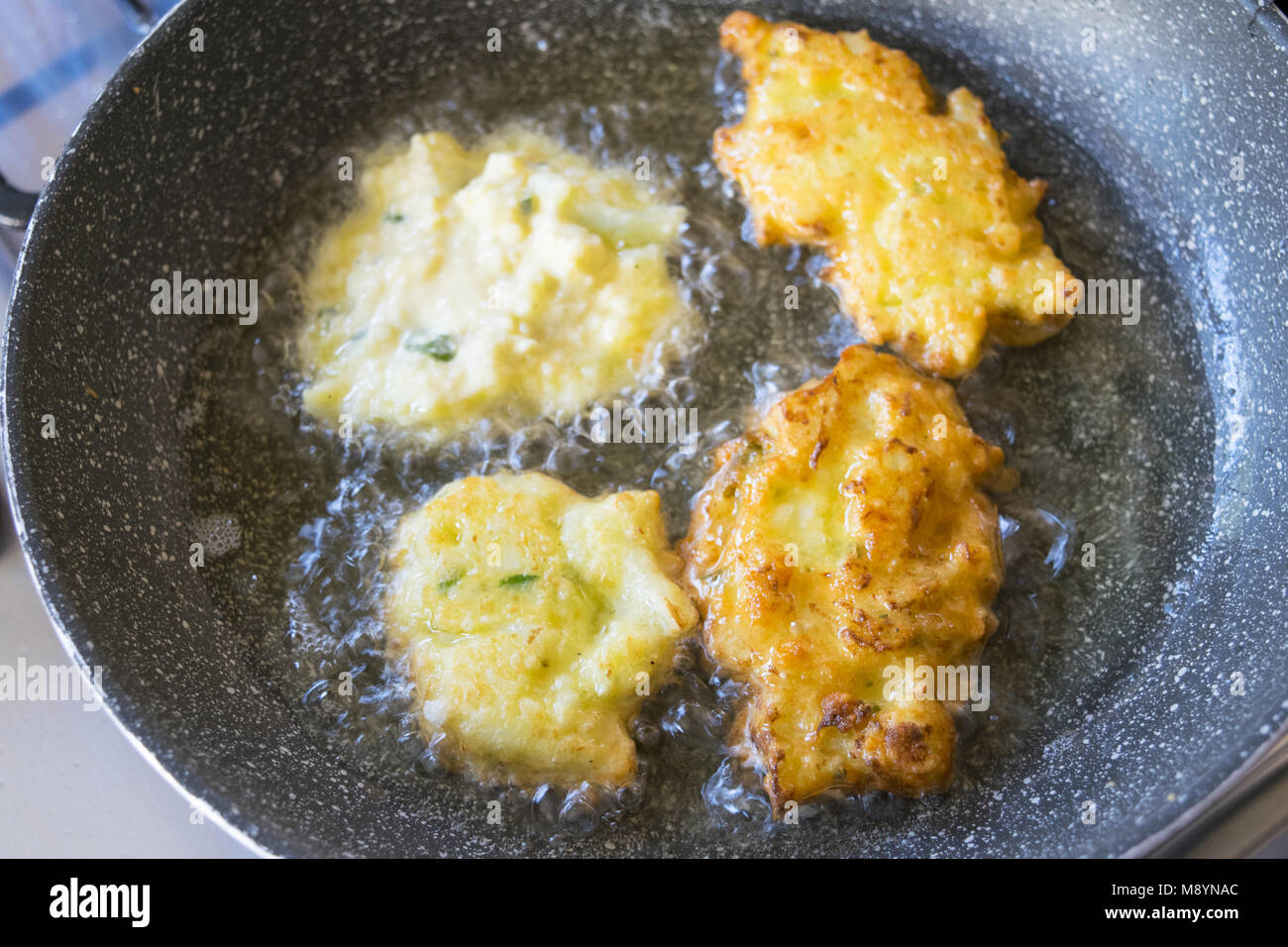 Frittelle di vegetariani la frittura in padella con olio bollente Foto Stock