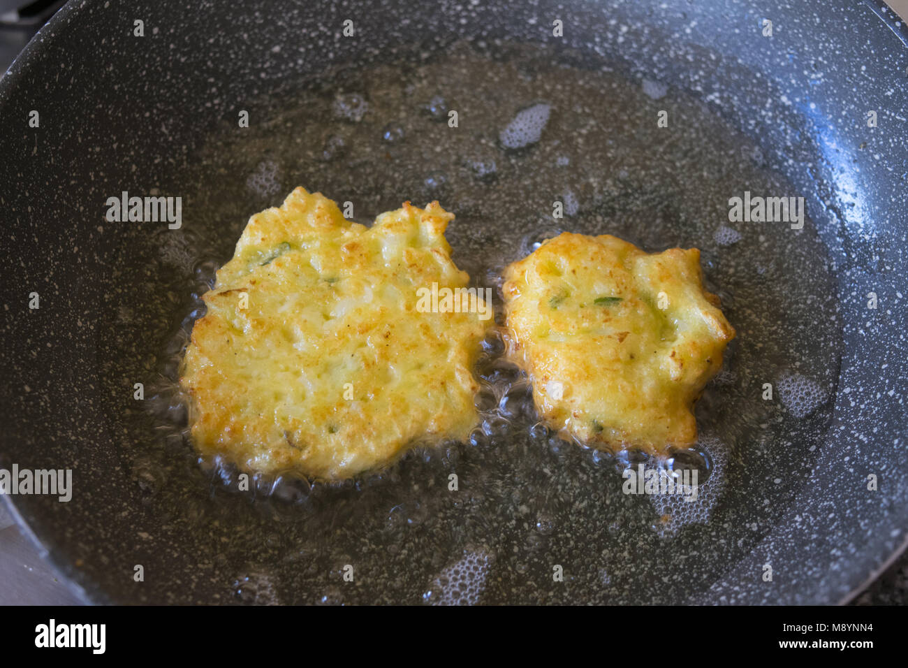 Frittelle di vegetariani la frittura in padella con olio bollente Foto Stock