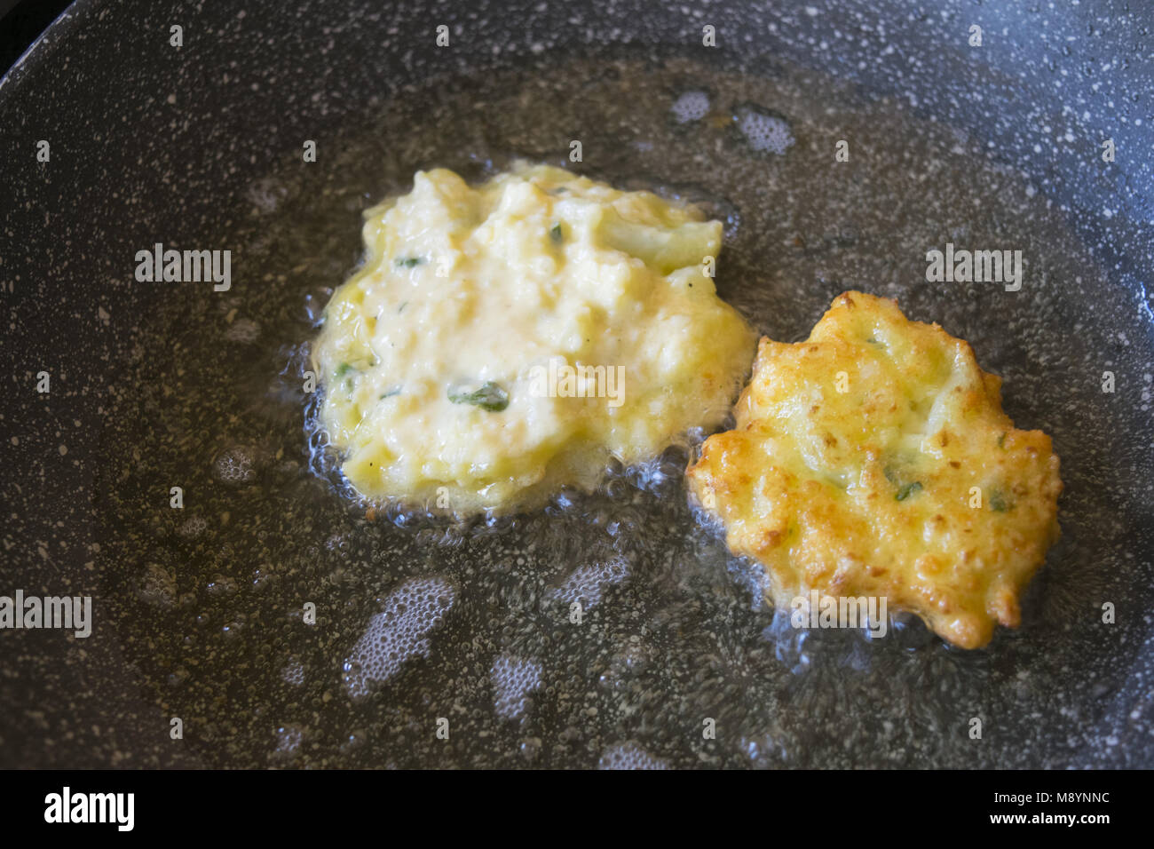 Frittelle di vegetariani la frittura in padella con olio bollente Foto Stock