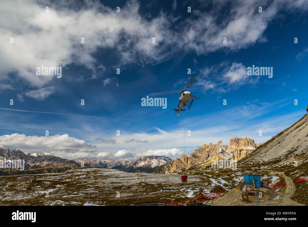 Elicottero usato per le operazioni di soccorso anche per portare i materiali di costruzione sul terreno Tre Cime di Lavaredo nelle Dolomiti, Italia. Foto Stock