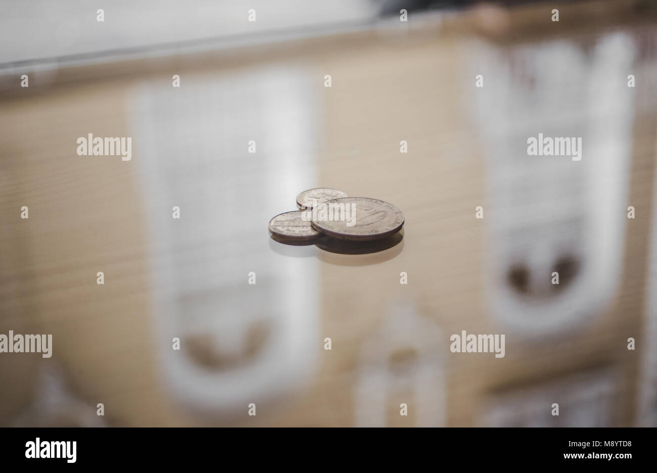 American 50 centesimi e due spiccioli / 10 centesimi di Euro monete su una superficie lucida di un coffee shop pronto per il pagamento Foto Stock