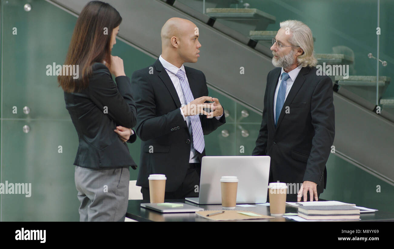 Multietnica aziendale dirigenti riuniti a discutere di affari in ufficio. Foto Stock