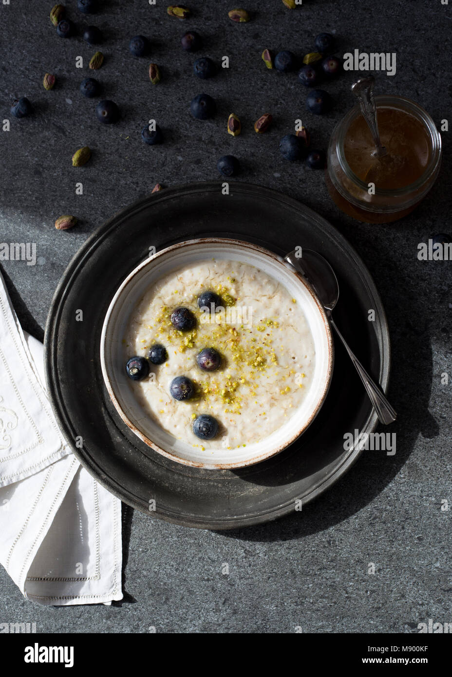 Porridge con miele, mirtilli e i pistacchi Foto Stock