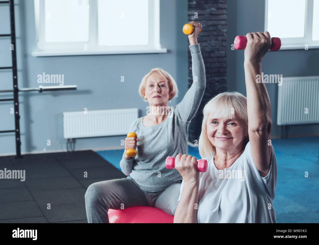 Sportivo le donne in pensione a fare gli esercizi con i pesi al fitness club Foto Stock