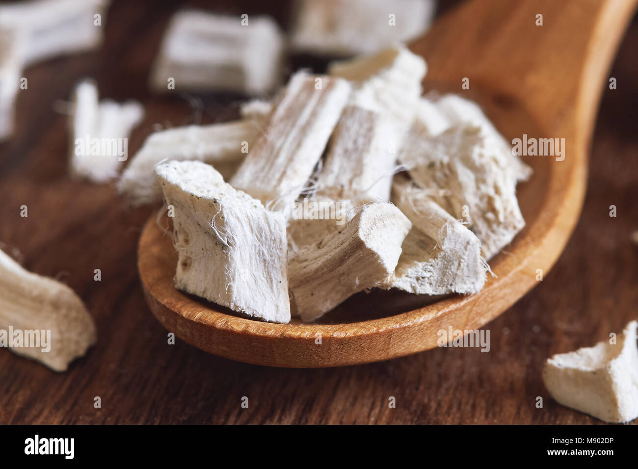 Essiccato e tagliato a fette marshmallow root (Althaea officinalis) in cucchiaio di legno Foto Stock