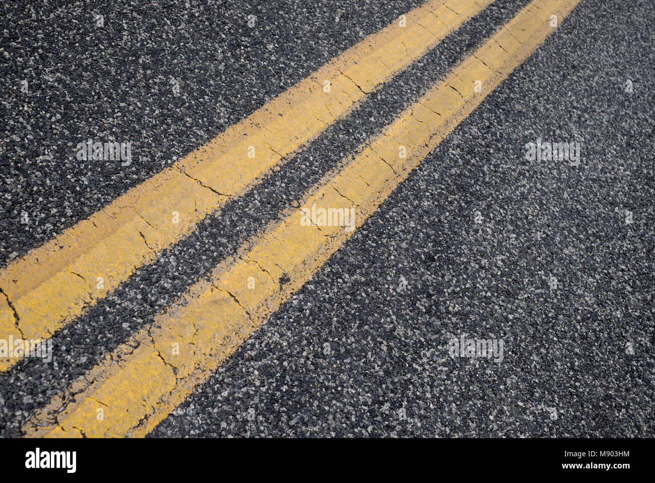 Doppio giallo street linee sul paese vecchio asfalto. Close up. Foto Stock