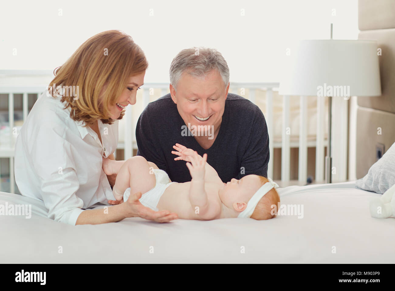 I nonni e il bambino sta giocando sul letto. Foto Stock