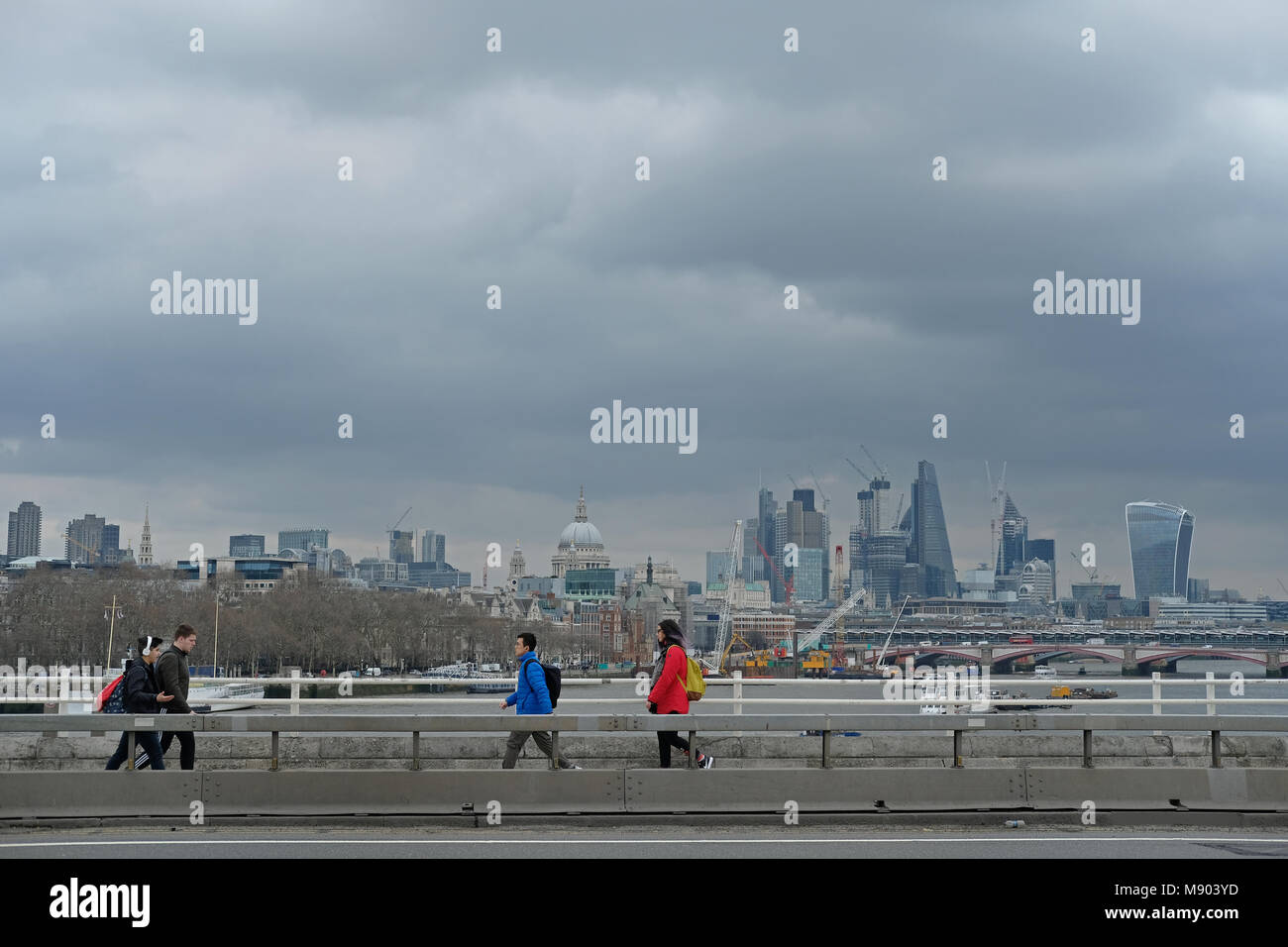 Persone attraversano Waterloo bridge in un giorno nuvoloso. Foto Stock