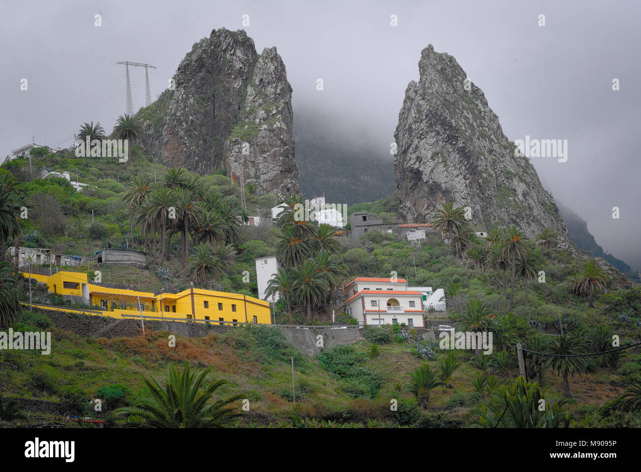 Suddiviso in montagna le nuvole, alcune abitazioni al di sotto di Foto Stock