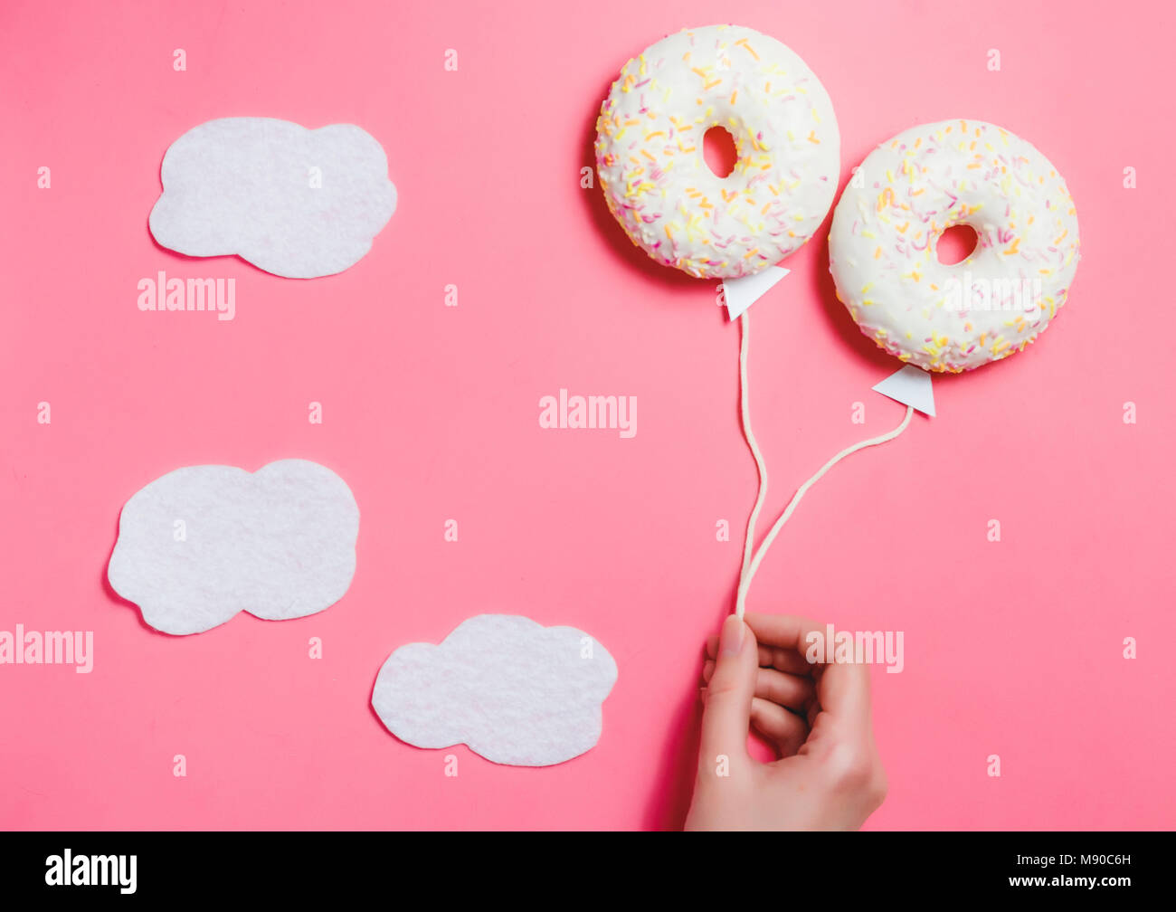 Donut su sfondo rosa, cucina creativa il minimalismo, la ciambella in forma di palloncino al cielo di nuvole, vista dall'alto con spazio copia, tonica Foto Stock
