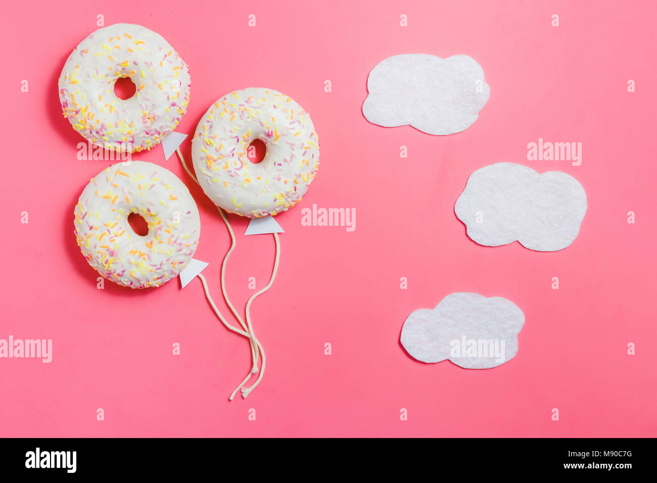 Donut su sfondo rosa, cucina creativa il minimalismo, la ciambella in forma di palloncino al cielo di nuvole, vista dall'alto con spazio copia, tonica Foto Stock