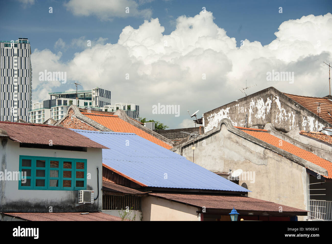 Paesaggio urbano colorato mostrante un contrasto di vecchio e nuovo in Malacca (Malacca), Malaysia. Vista sul tetto di un vecchio magazzino oltre a moderni centri commerciali Foto Stock