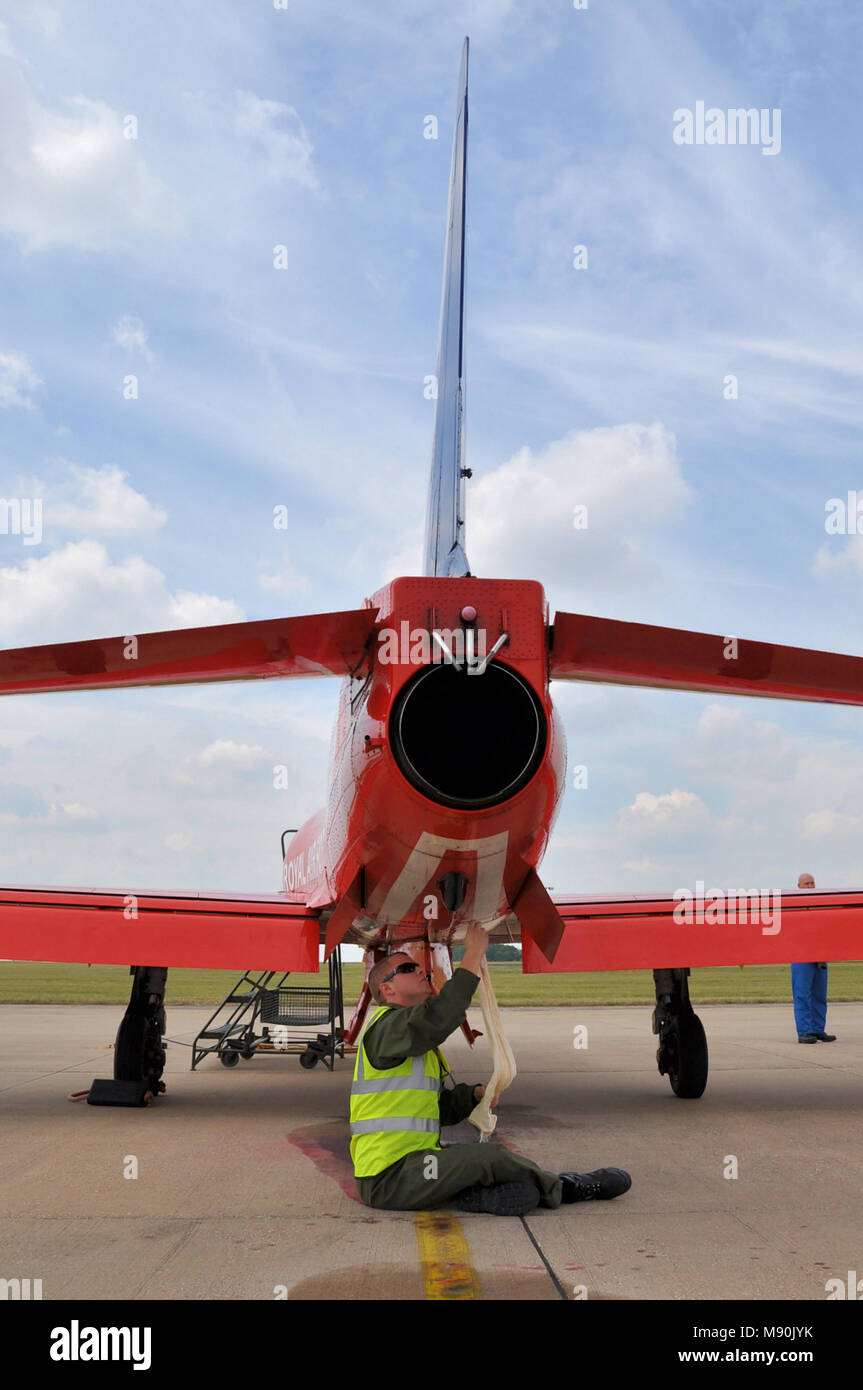 Ingegnere meccanico che lavora su un Royal Air Force frecce rosse BAe Hawk T1 piano a getto a RAF Scampton. Il lavoro. La manutenzione. Il tubo di scarico. Tubo a getto. In aereo Foto Stock
