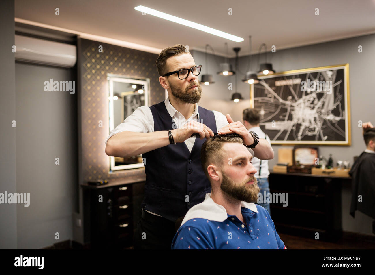 Ritratto di parrucchiere pettinatura dei capelli del cliente Foto Stock