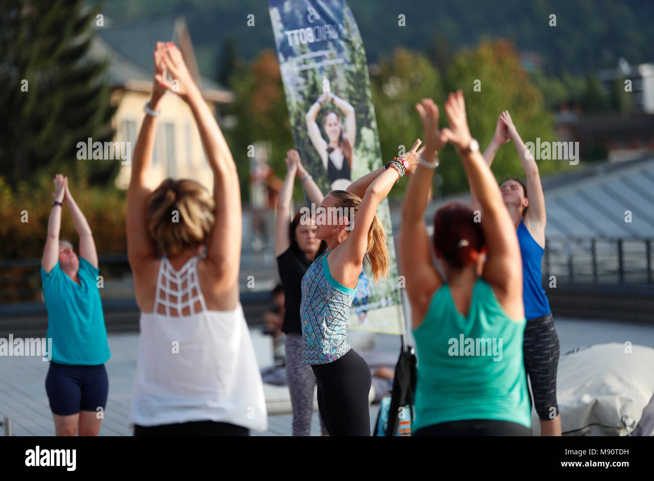 Grande lezione di yoga bracci di estensione verso l'alto. Saint-Gervais Mont-Blanc. La Francia. Foto Stock