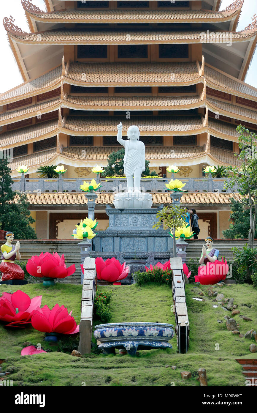 Minh Dang Quang tempio buddista. Ragazzo statua del Buddha in cima alle scale con lunghe-orecchie, calvo e un dito puntato verso il cielo. Ho Chi M Foto Stock