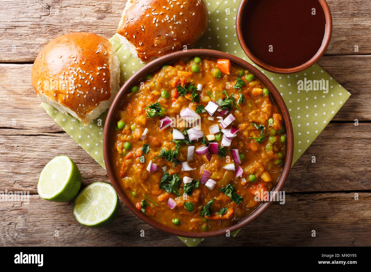 Pav Bhaji speziato indiano il fast food con pane Paav close-up in una ciotola sul tavolo. Parte superiore orizzontale vista da sopra Foto Stock