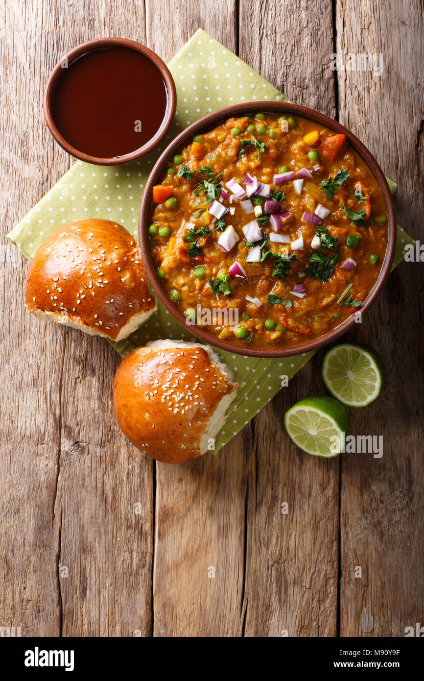 Indian Mumbai cibo Pav bhaji dalle verdure con pane di close-up in una ciotola sul tavolo. Verticale in alto vista da sopra Foto Stock
