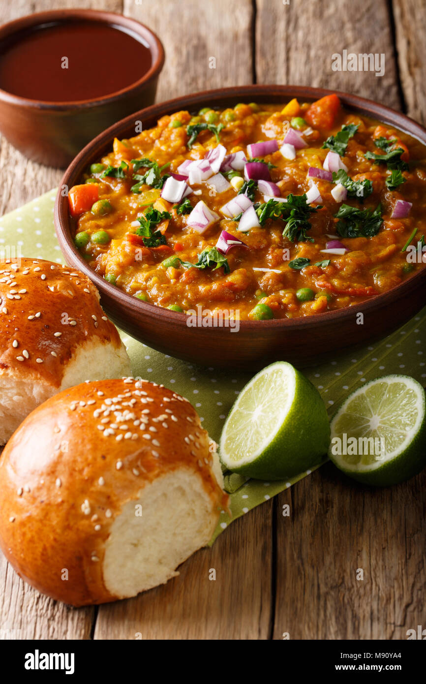 Indian Mumbai cibo Pav bhaji dalle verdure con pane di close-up in una ciotola sul piano verticale. Foto Stock
