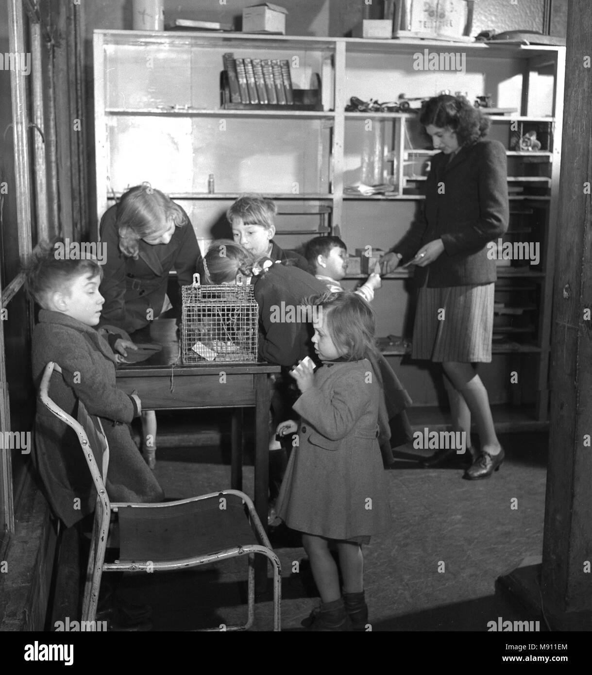 Degli anni Cinquanta, storico, post-ww2 e bambini piccoli nelle loro tuniche con insegnante in una scuola materna, Inghilterra, Regno Unito. Foto Stock
