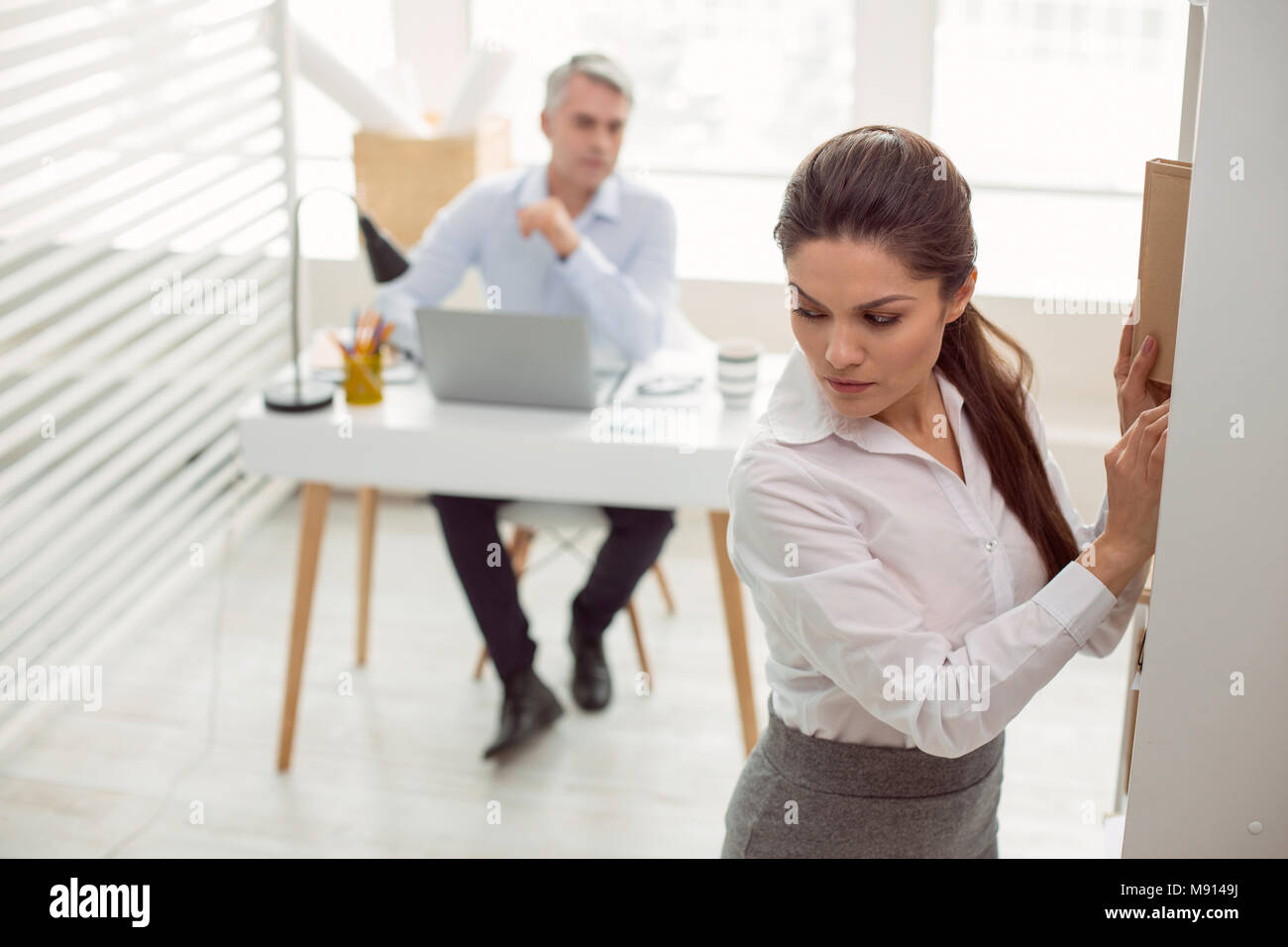 Piacevole donna attraente lavora in ufficio Foto Stock