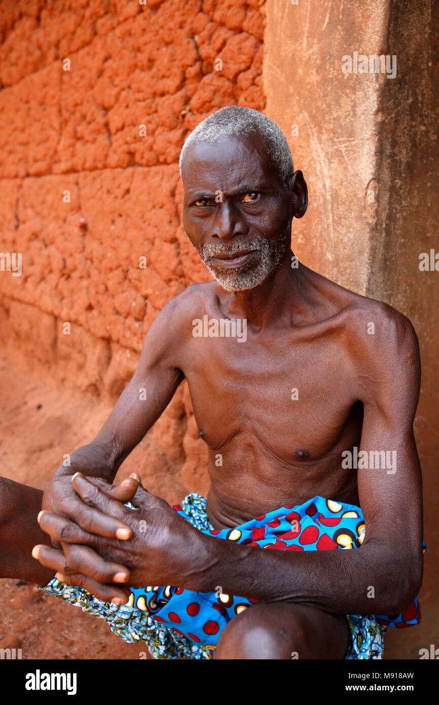 Anziani uomo seduto al di fuori della sua casa in un Affermazione di Zou provincia village, Benin. Foto Stock