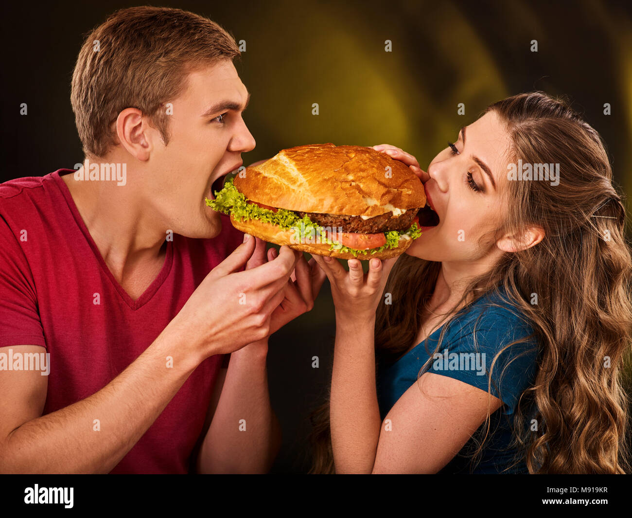 Paio di mangiare fast food. L uomo e la donna il trattamento di hamburger . Foto Stock