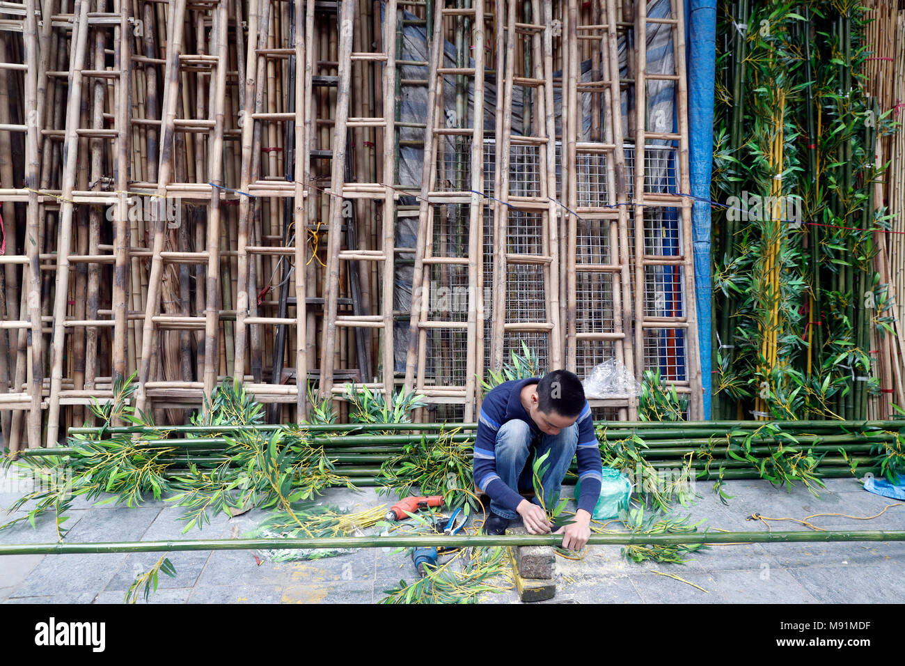 Uomo che rendono la plastica di alberi di bamboo. Hanoi. Il Vietnam. Foto Stock