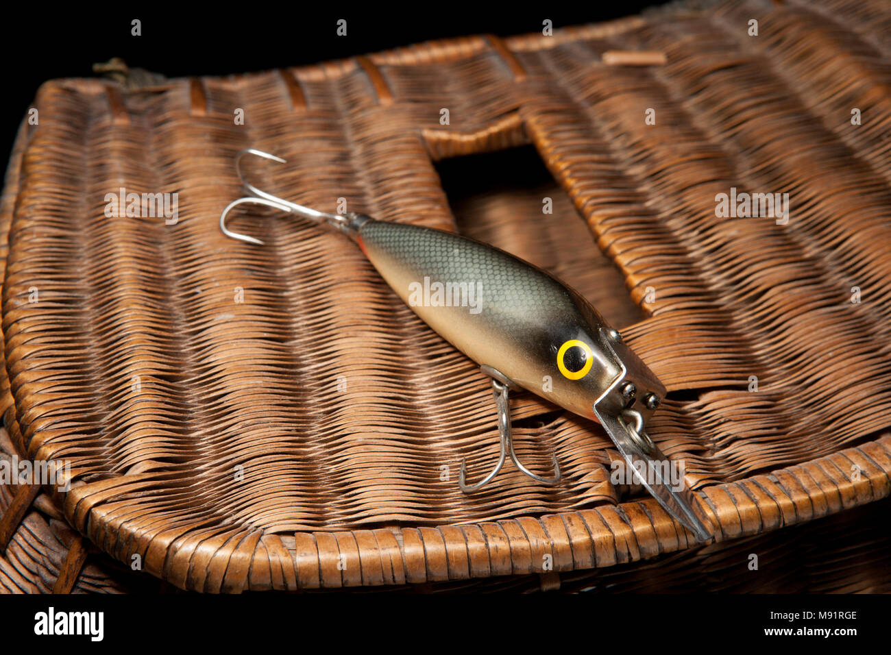 Vecchia esca artificiale o il tappo, eventualmente da boschi MFG su di una cantra e sfondo nero. Da un'annata di pesca raccolta nel Regno Unito Foto Stock