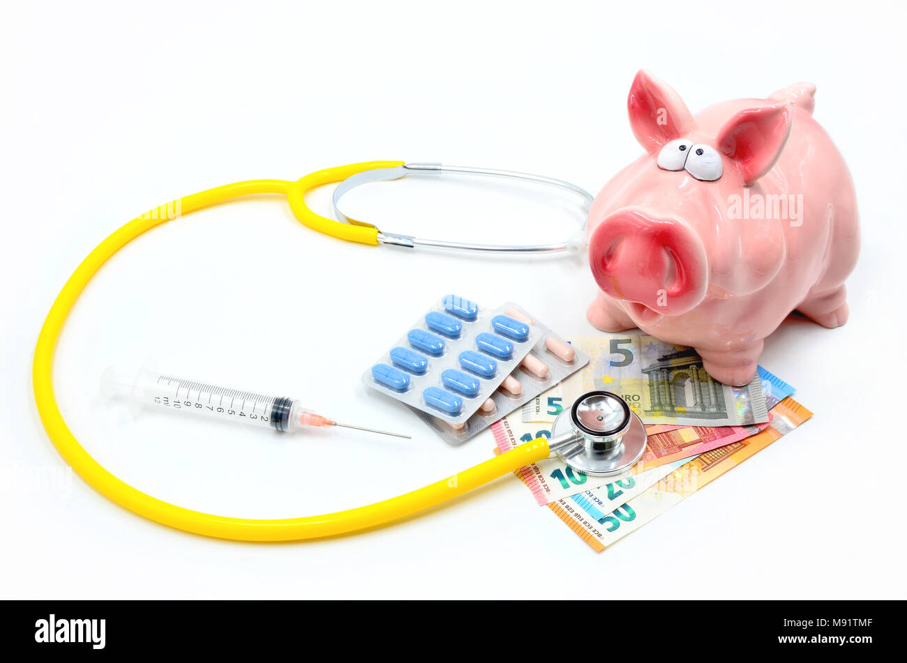 Piggybank con stetoscopio, le banconote in euro, pillole e la siringa isolato Foto Stock