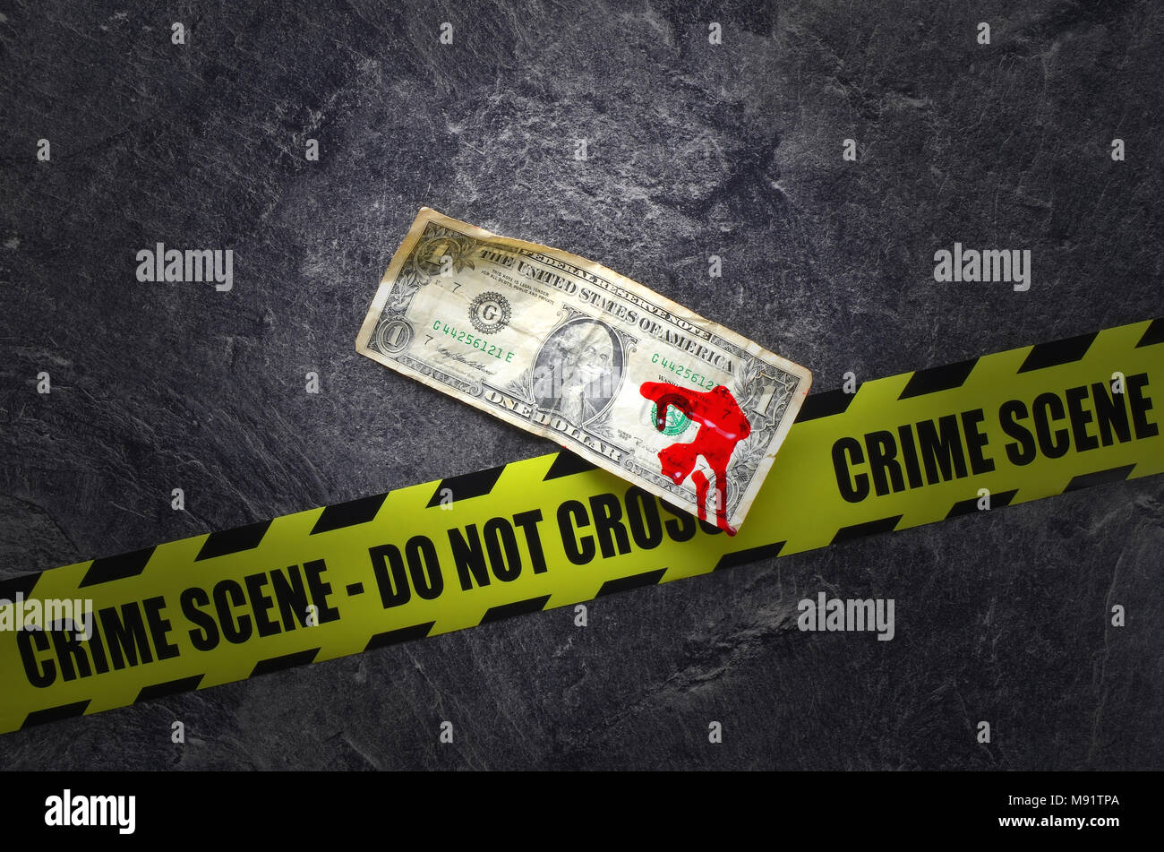 Dollaro con il sangue su di uno sfondo scuro con non cross crime scene tape Foto Stock