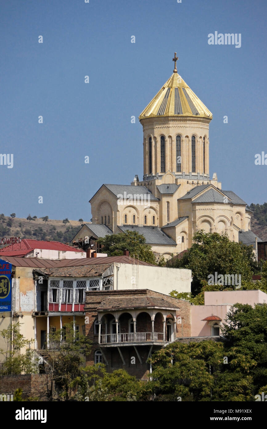 Tsminda Sameba (Santa trinità) Cattedrale su una collina dietro la vecchia, balconied edifici, Tbilisi, Georgia Foto Stock