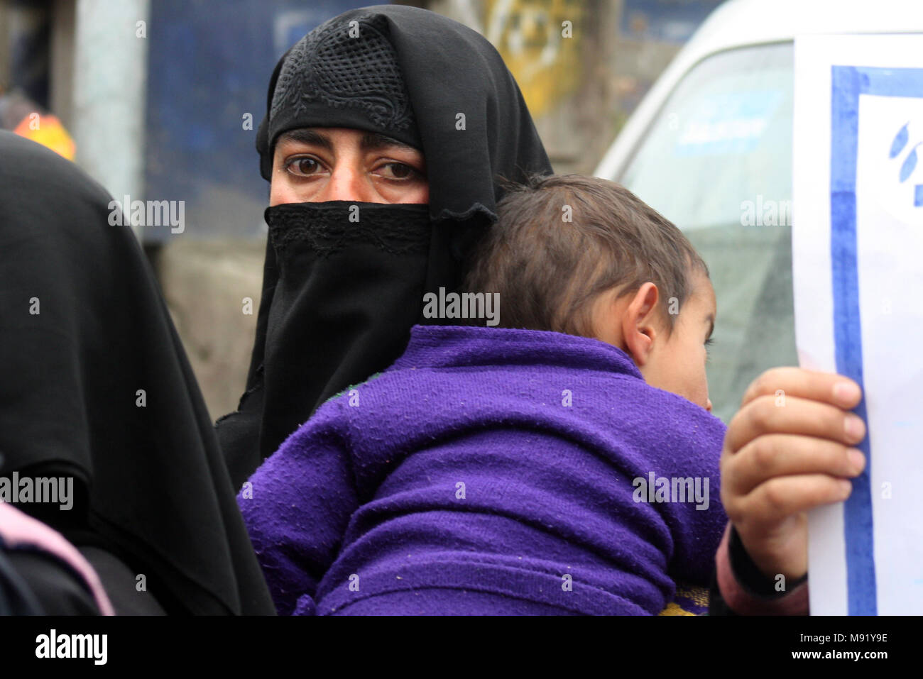 Srinagar Kashmir. Xxi Mar, 2018. Un membro del Kashmir Tehreek-e-Khawateen (KTK), donne gruppo separatista, mantiene il suo bambino durante una manifestazione di protesta contro i massacri civili lungo la linea di controllo (LOC). Protestando KTK membri preteso fine a sgranare attraverso LoC lungo con la risoluzione della questione del Kashmir attraverso mezzi pacifici Credito: sofi suhail/Alamy Live News Foto Stock