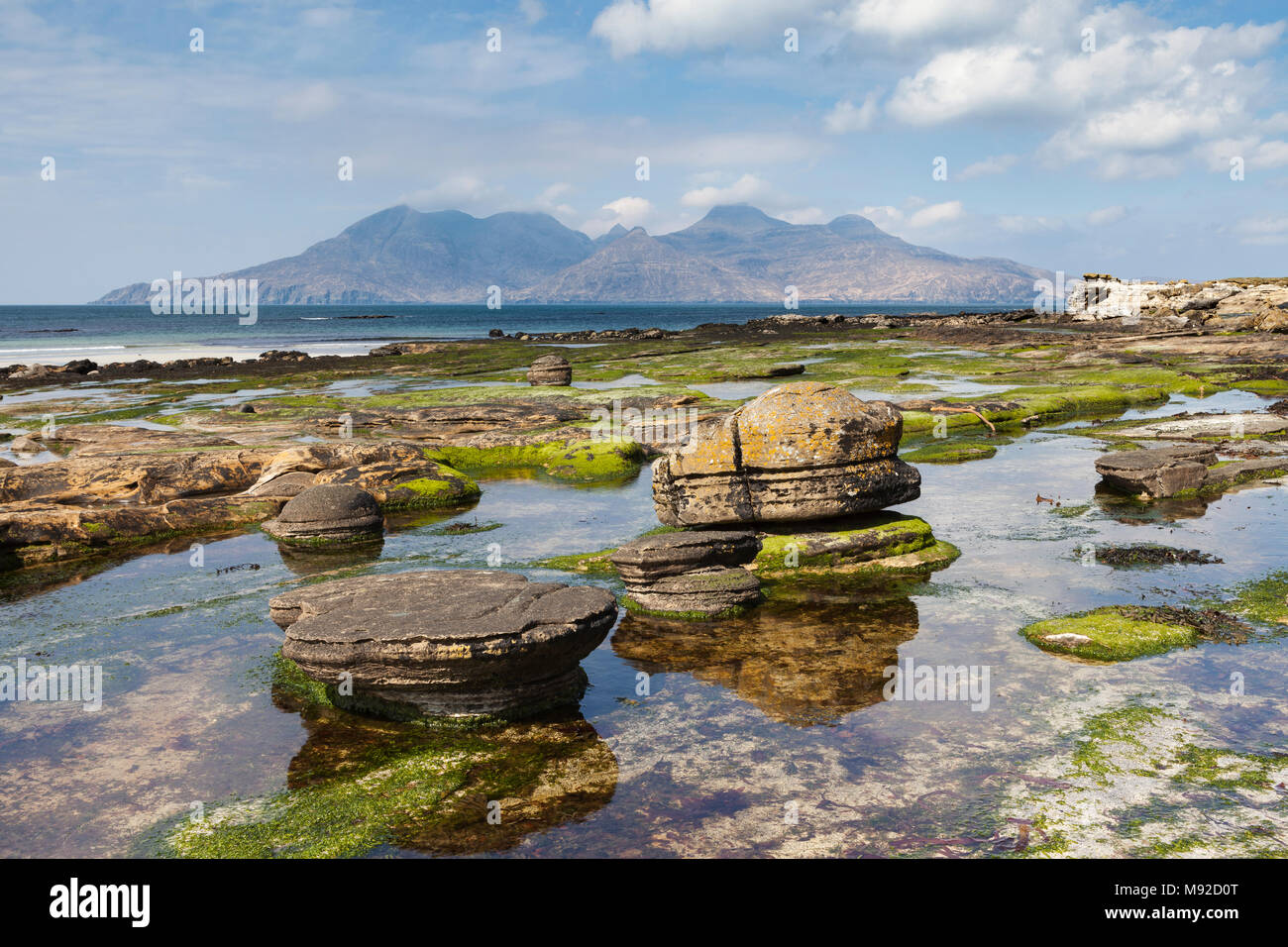 Concrezioni di arenaria presso la baia di Laig sull'Isola di Eigg, Ebridi Interne, Scozia. Le montagne in distanza sono sull'Isola di rum. Foto Stock